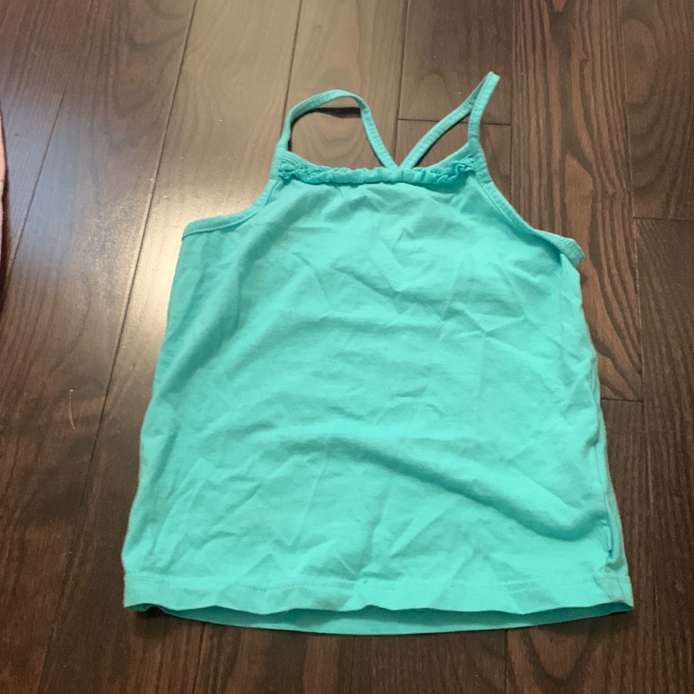 Turquoise tank top crossed straps.